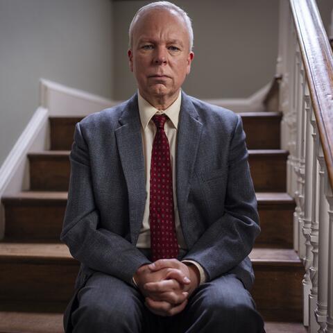 Actor Steve Pemberton sat on a stairs in a historic house