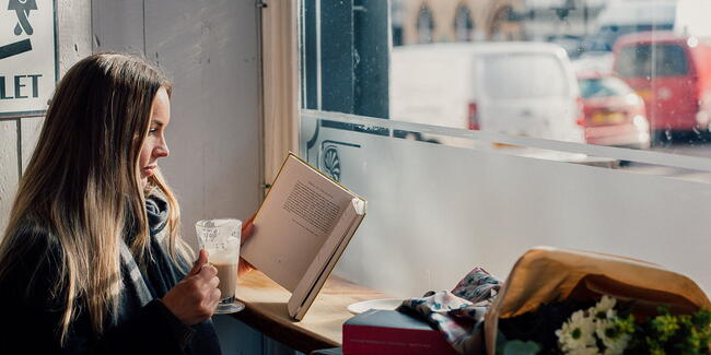 Woman reading book in cafe