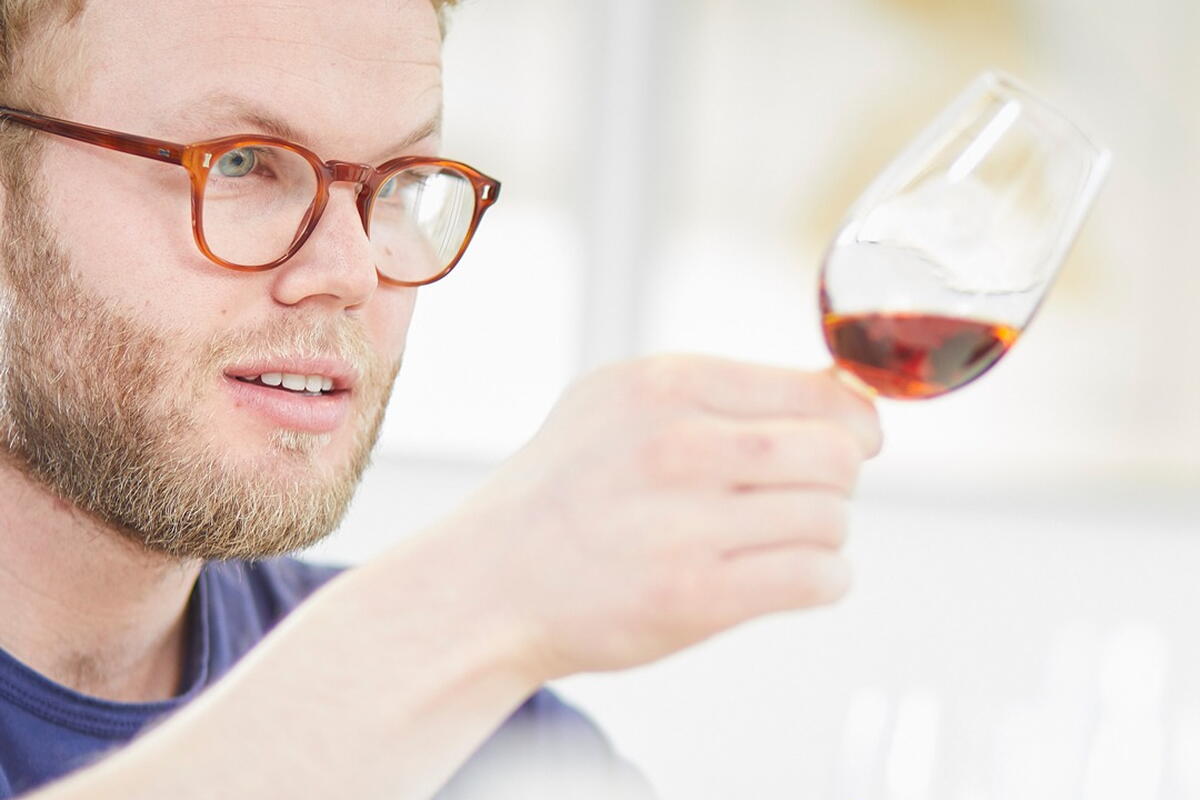 man with glasses and red wine in a glass