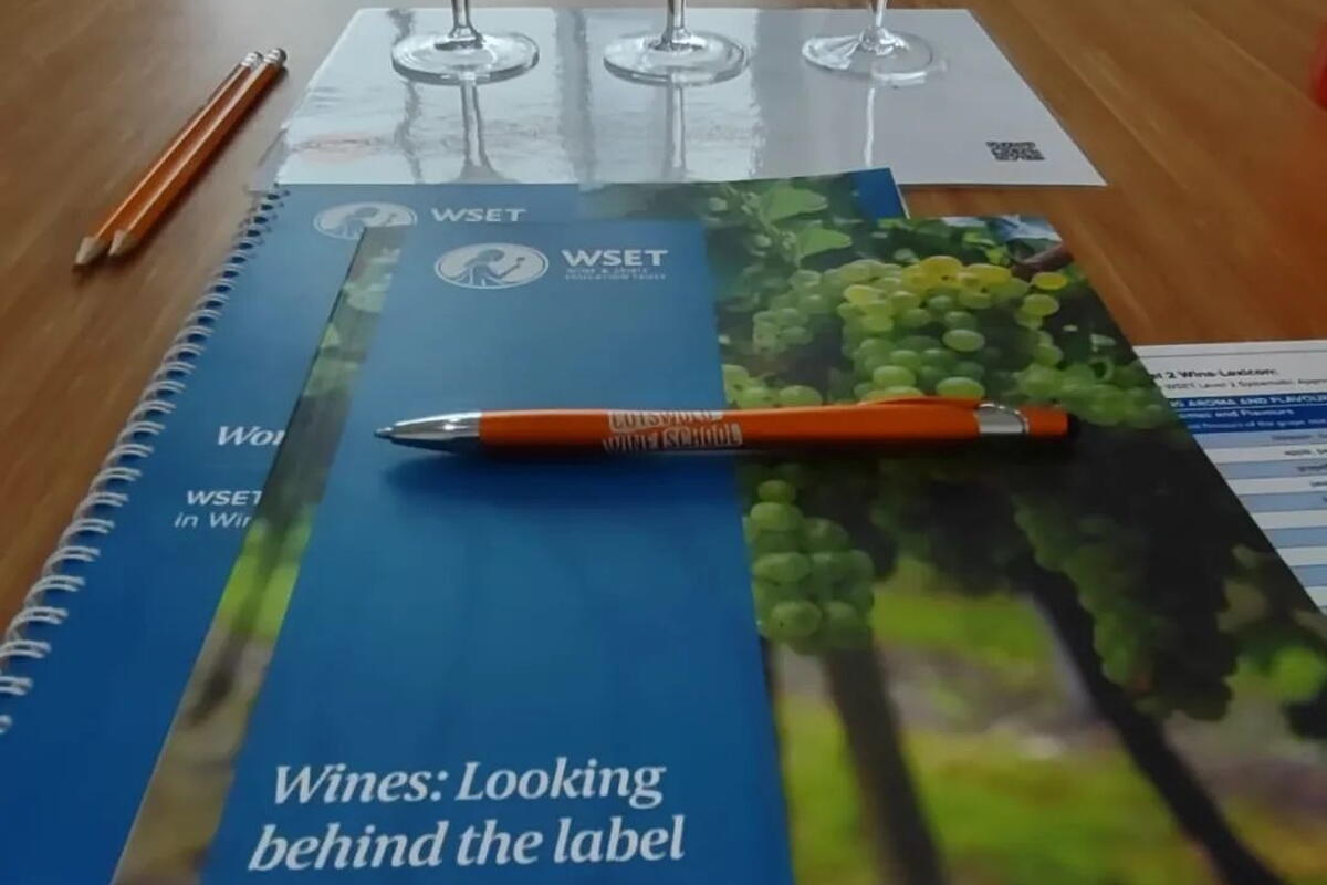 textbook with empty wine glasses and pen