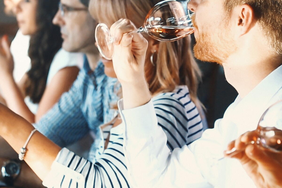 group of people sat at a table tasting wine