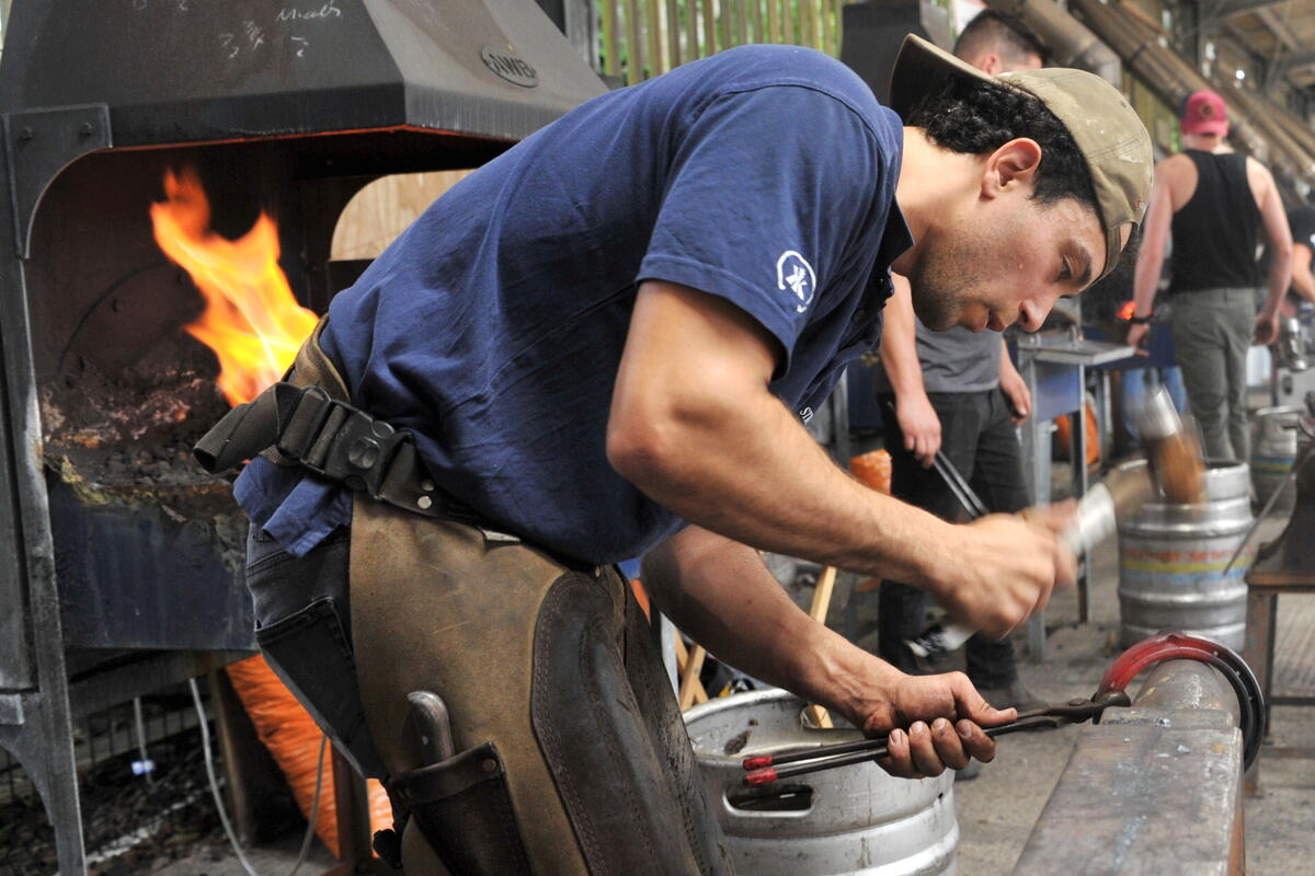 Farrier shaping horse shoes