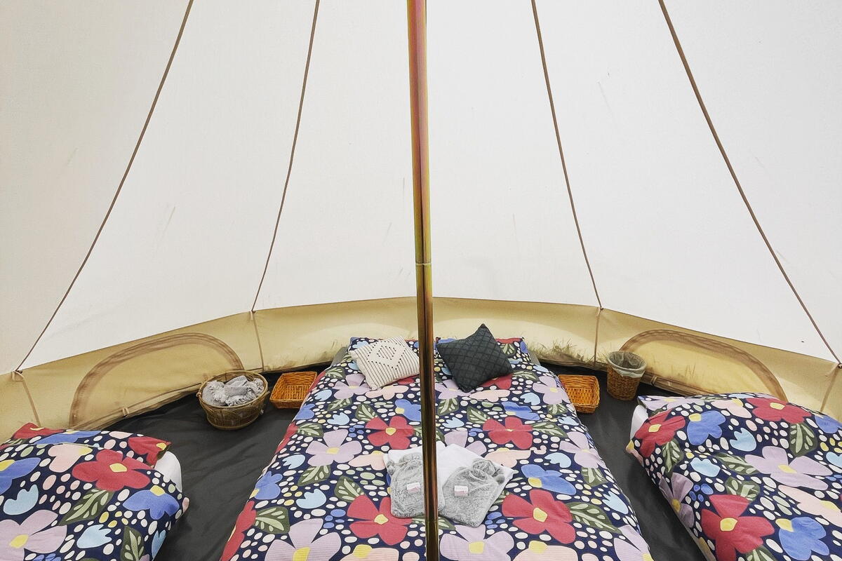 Inside bell tent with three beds