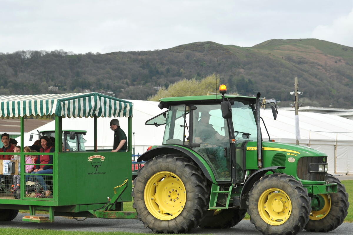 Tractor pulling trailer with people on 