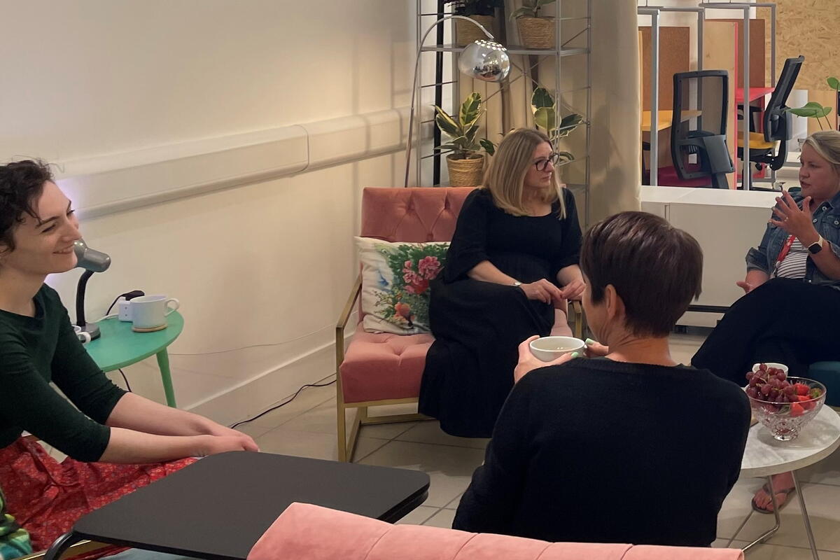 Ladies sat in armchairs sharing stories