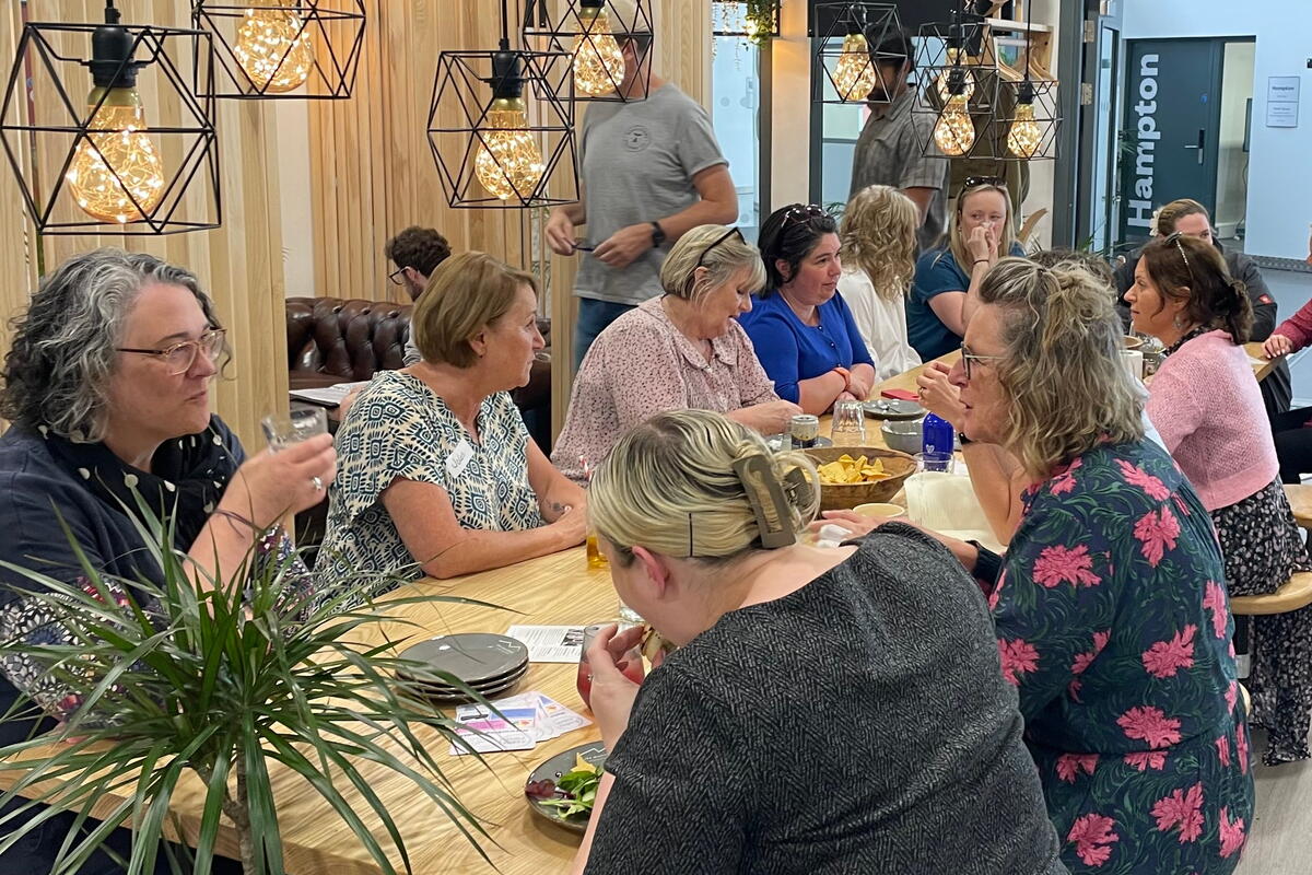 ladies sat around large dining table in a cafe