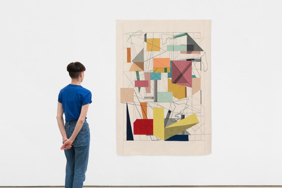 Man stood in front of abstract artwork on white wall