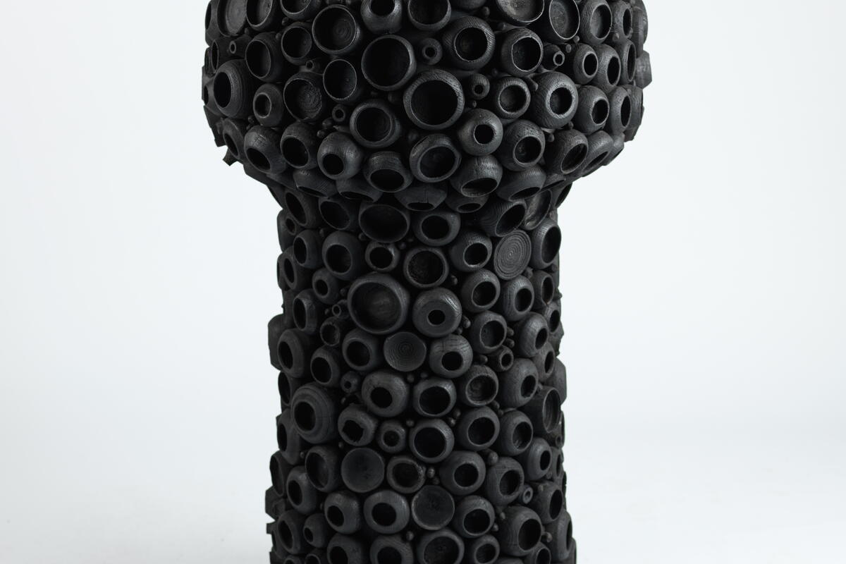 sculpture with black cup-like shapes all over the outside