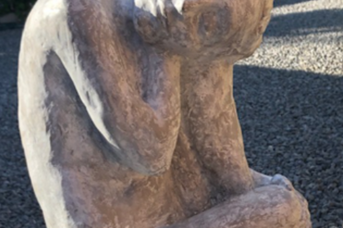 stone sculpture of a figure sitting
