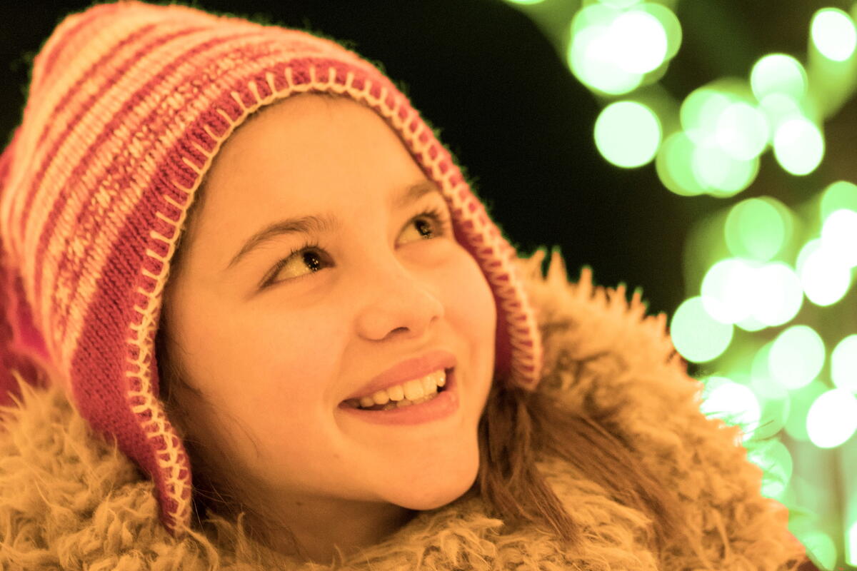 Girl dressed for winter enjoying spooky lights