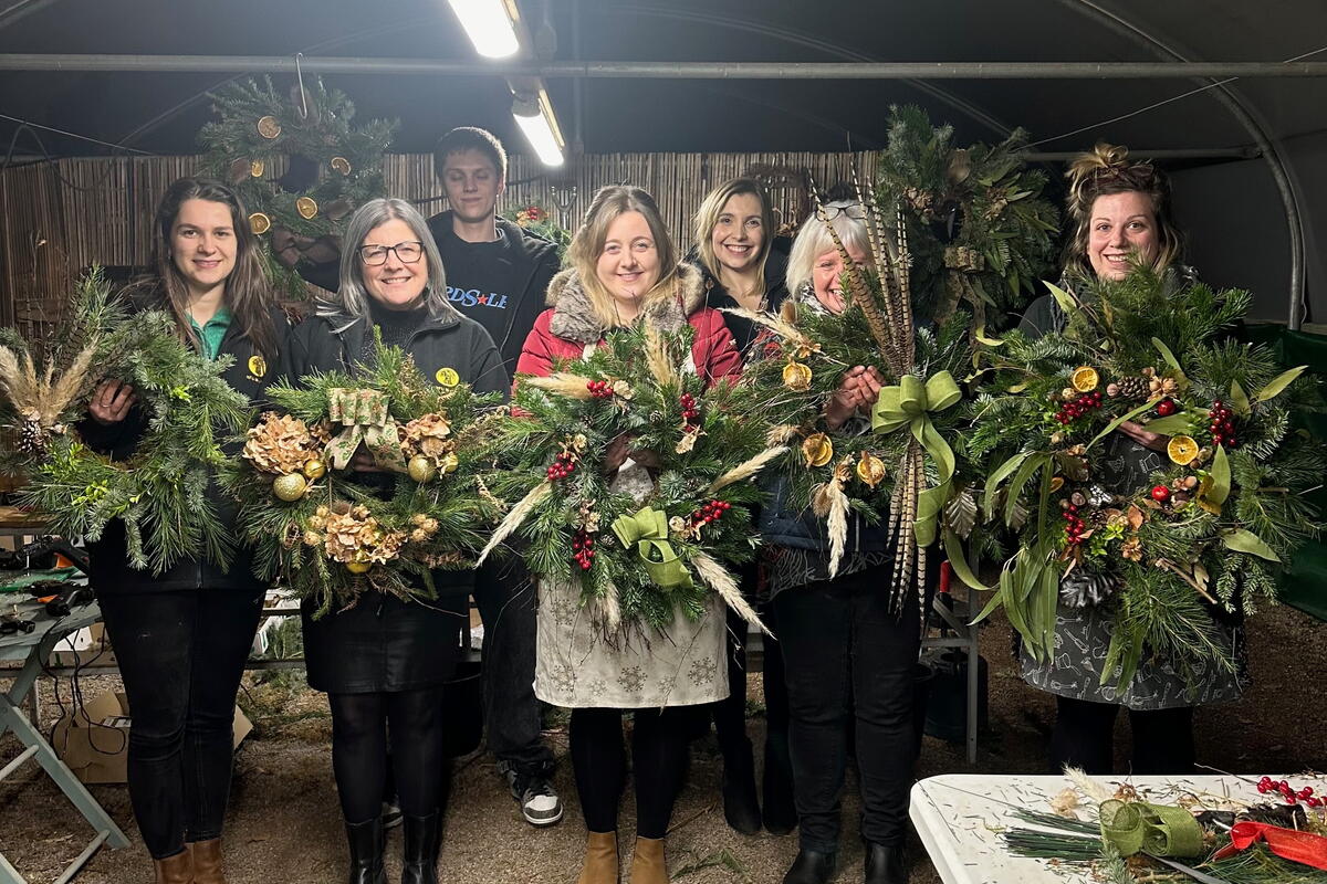 Group of people holding handmade Christmas wreaths