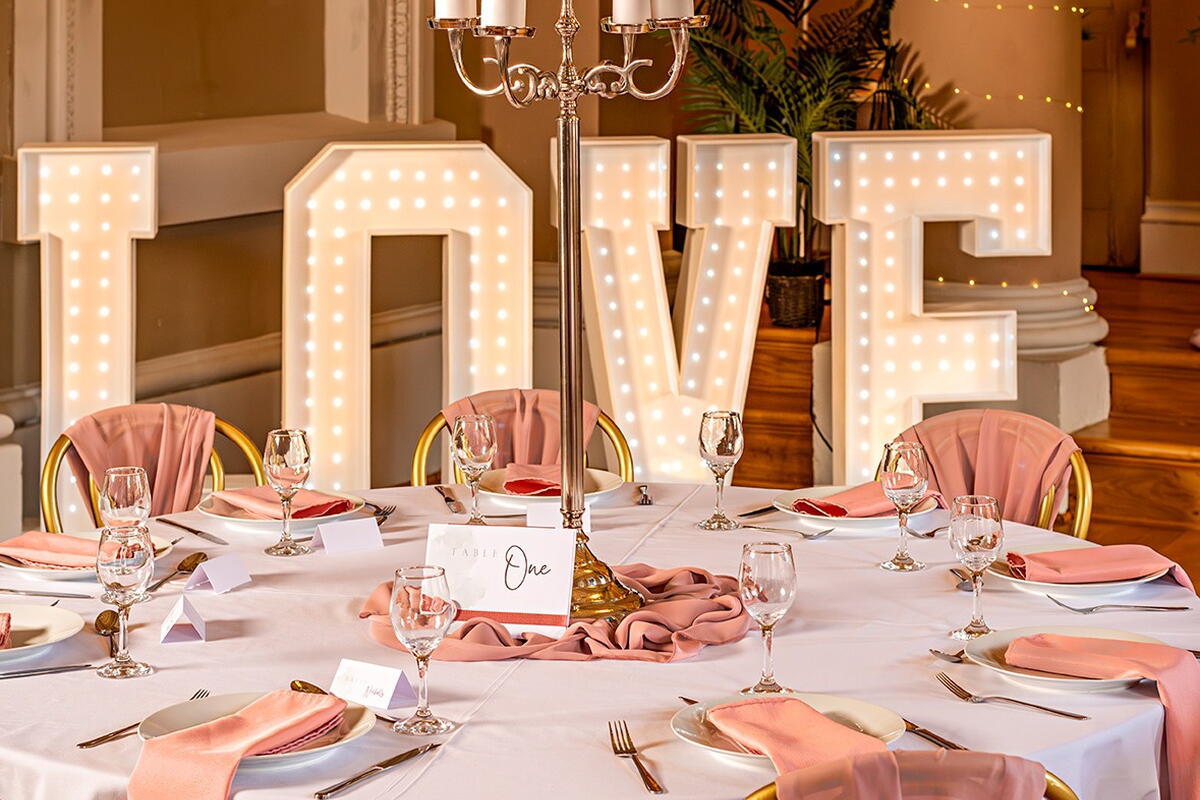 table set for  wedding breakfast with a very large LOVE sign