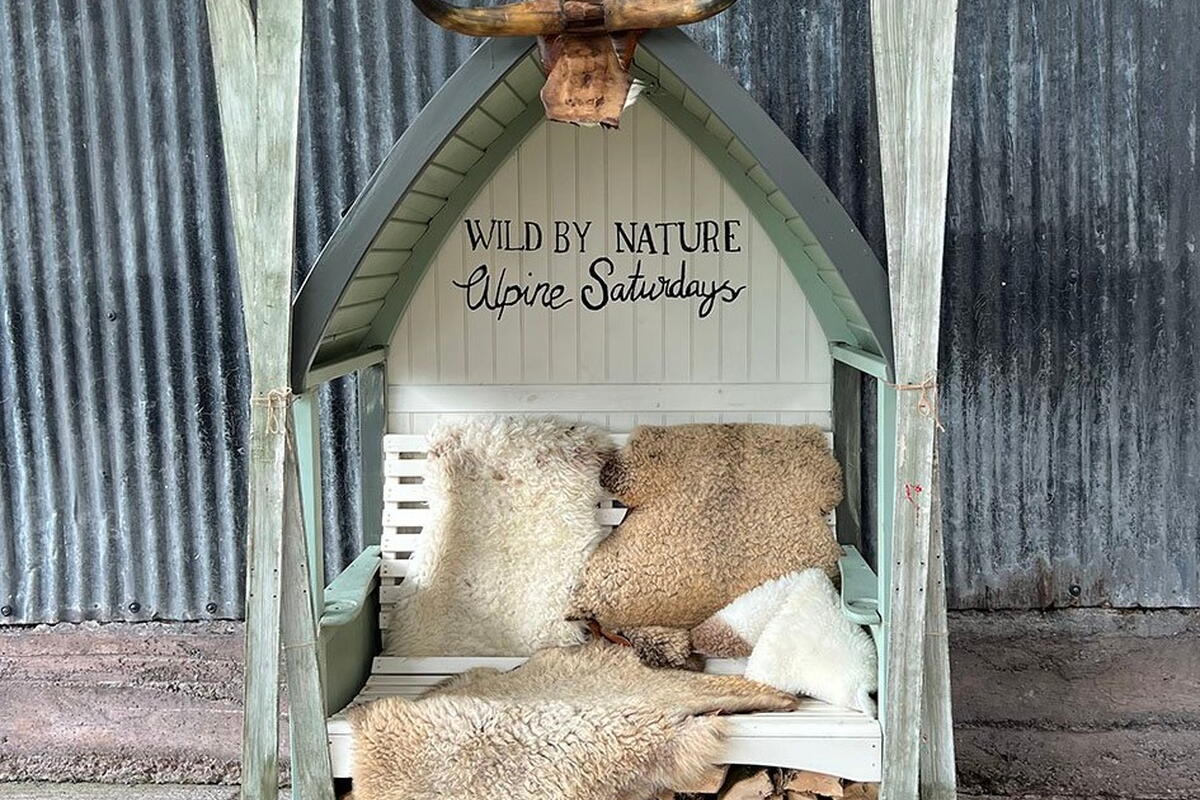 Wild by nature Alpine Saturdays wooden bench with skis on either side and long horn cow horns