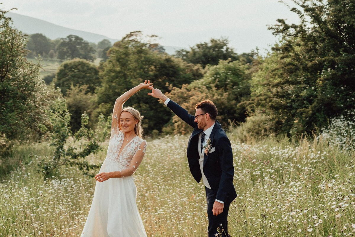 a bride and groom in a meadow