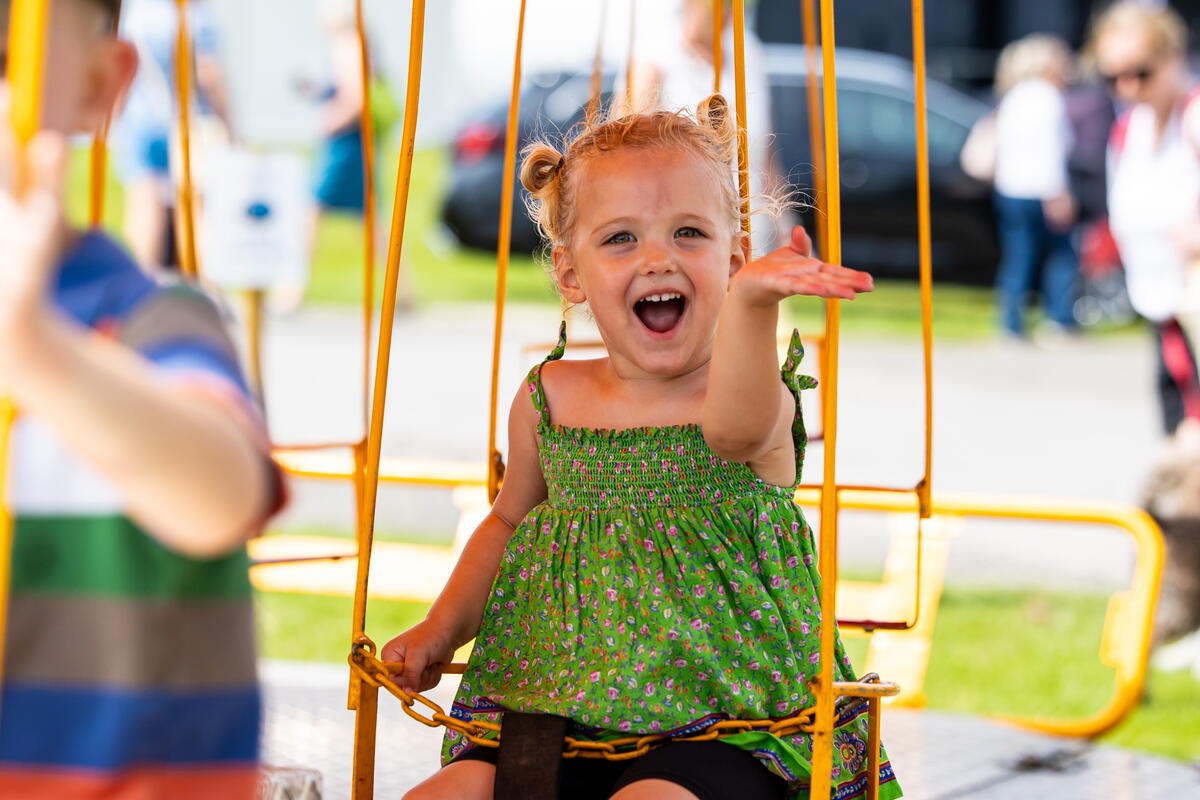 a child on a fairground swing ride