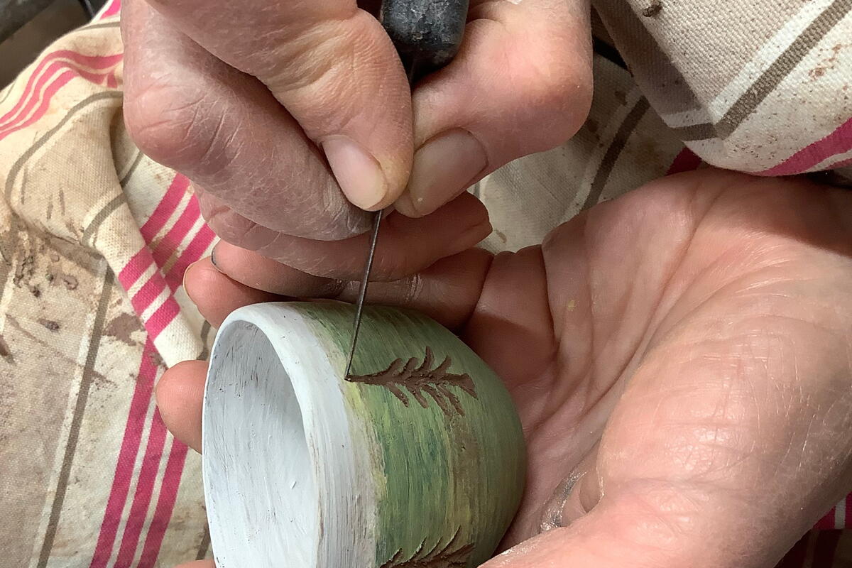Turned pots being decorated before firing