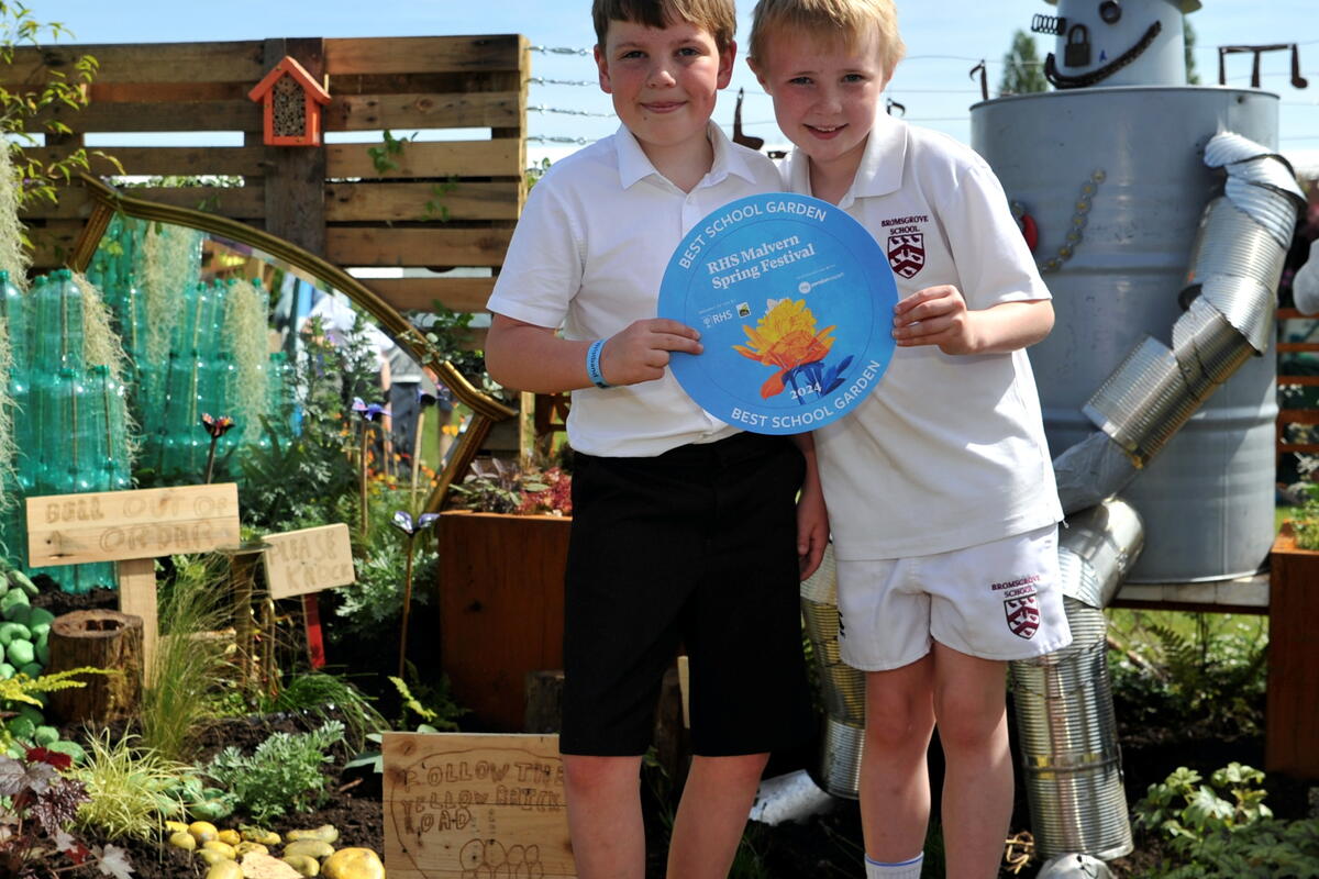 Children with a certificate in a garden at the RHS Malvern Spring show 
