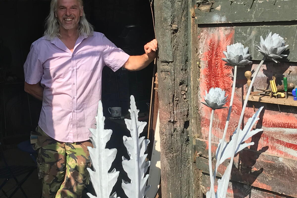 man with pewter sculptures in organic long leaf-like designs