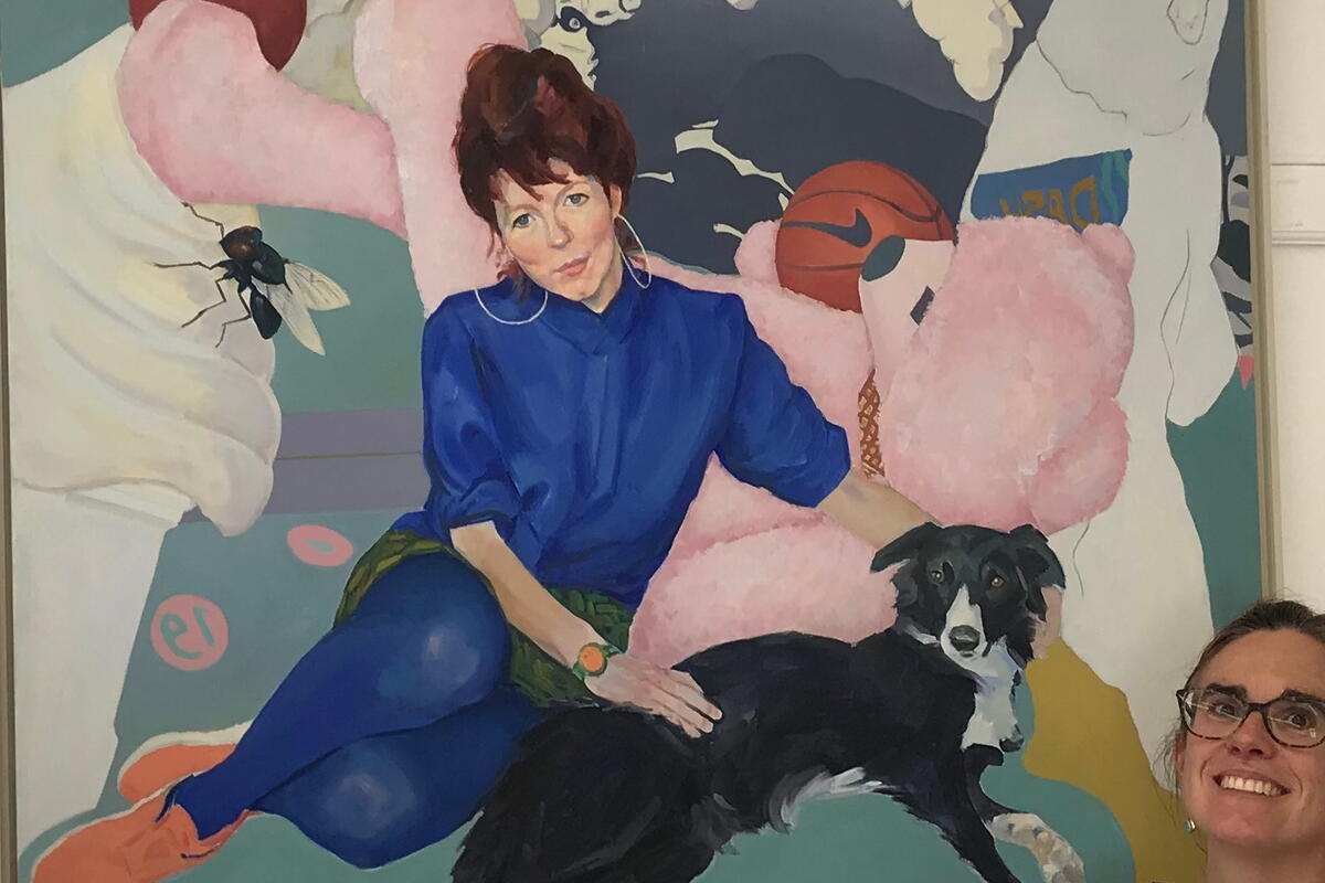 person with a large painting of a woman, dogs, bee and plants