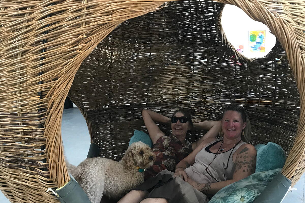 people sat in a woven hanging swing chair