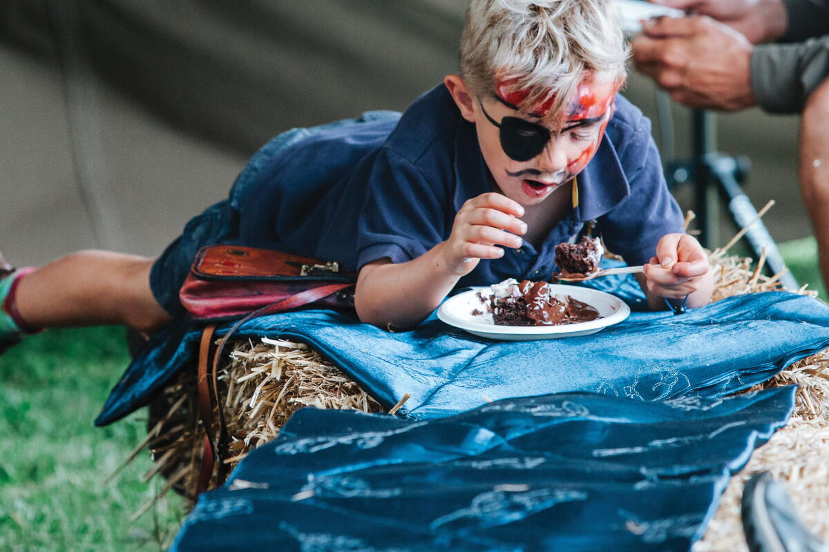 child with face paint and cake