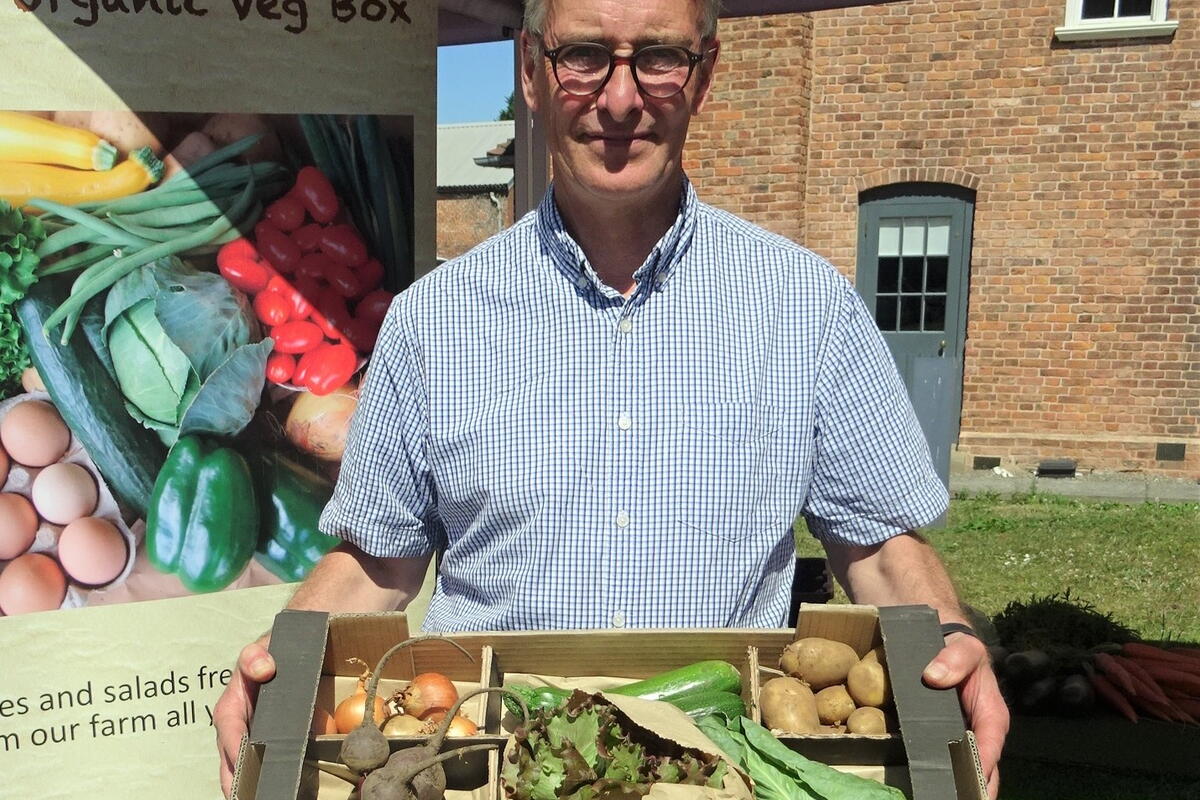 man holding box of vegetables