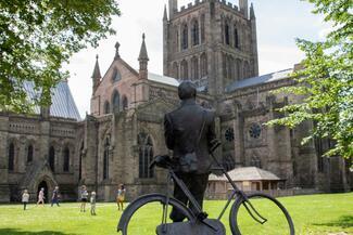 Statue of Elgar with his bicycle looking up at the Cathedral