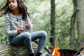 Girl roasts marshmallows in woodland