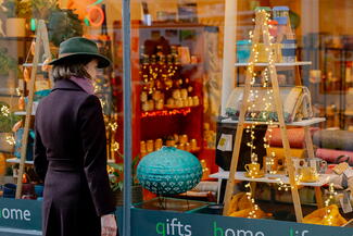 Woman looking through Christmassy shop window