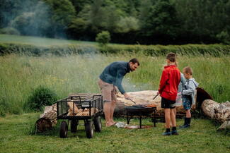 Family gathered near a firepit 