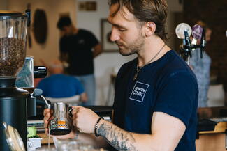 Young man pouring a pint of cider