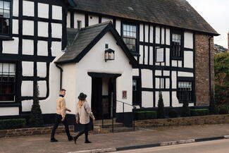 Young couple walking towards traditional black and white pub