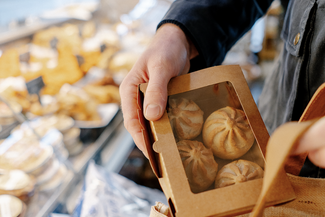Putting mini pork pies in a shopping bag