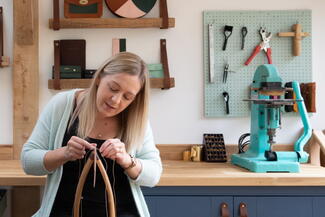 woman making hand made leather goods