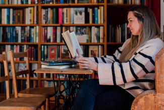 Girl reads a book at a table in Hereford