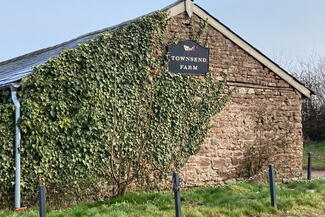 View of a building on Townsend Farm, enveloped with a climbing plant