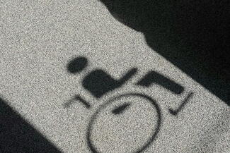 Shadow of a wheelchair symbol appears on a floor