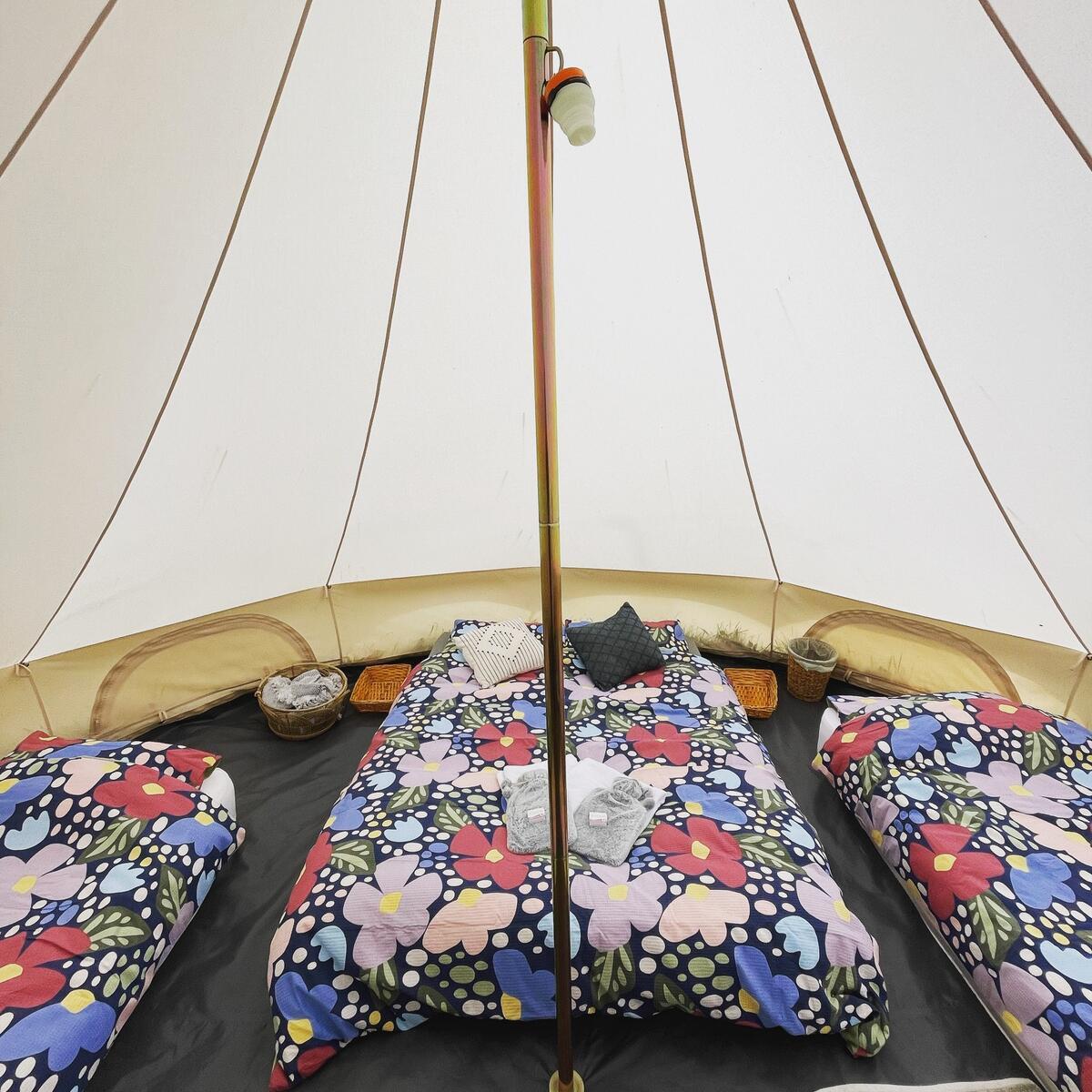 Inside bell tent with three beds