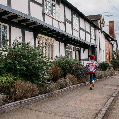 Child skipping past The Throne, Weobley