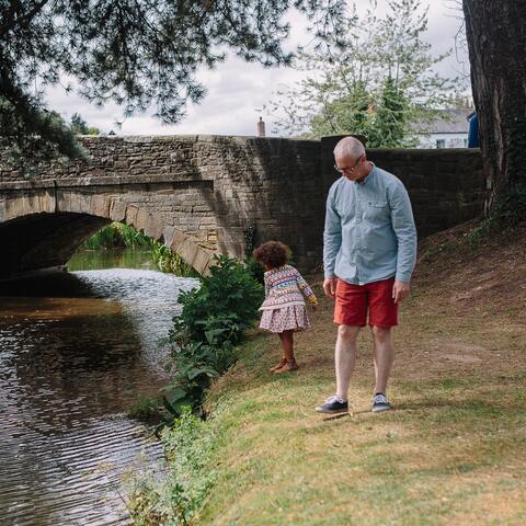 Father and daughter by river in Eardisland