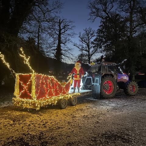 tractor and sledge lit up with fairy lights