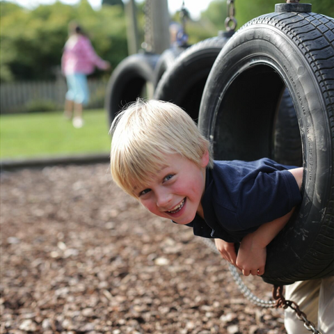 Boy poking his head through a tyre on the obstacle course