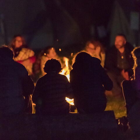 A wassailing ceremony with people sat around a fire