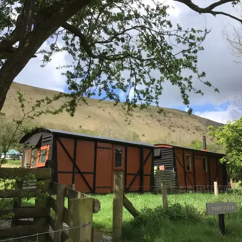 cabins nestled in a field within a deep valley