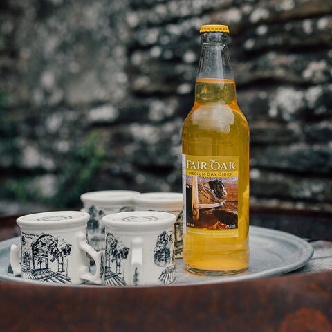 Bottle of Cider with mugs
