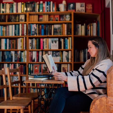 Woman reading sat down in bookshop cafe