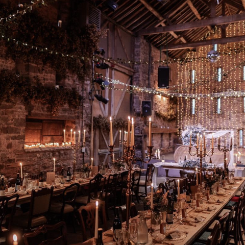 Barn with long dining tables and twinkly lights