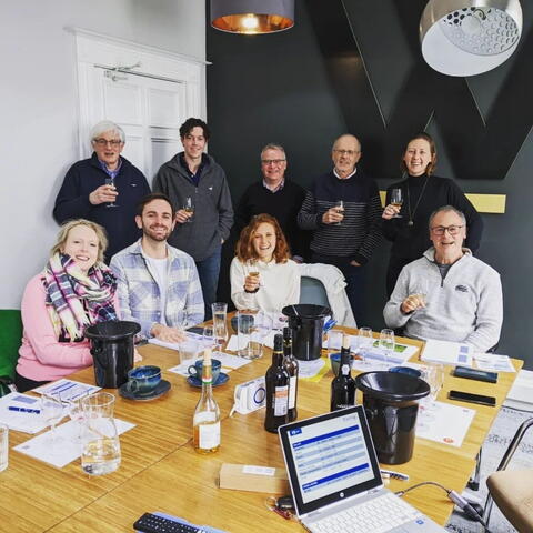 group of people with wine glasses around a large table