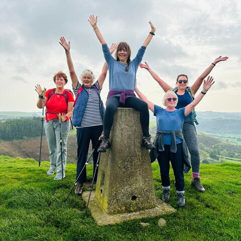 walkers with hands in the air by stone