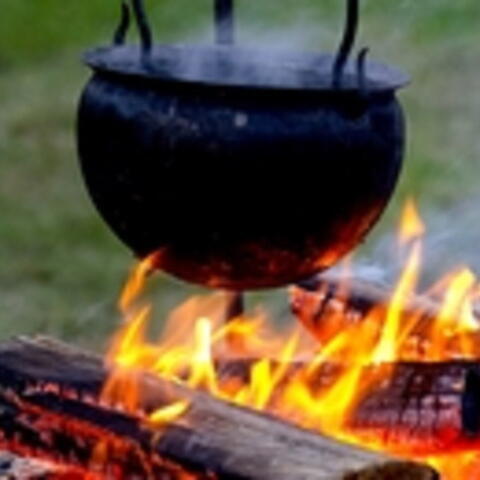 large pot hanging over a camp fire